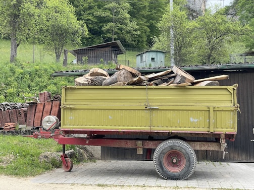 a yellow truck with a pile of wood in the back