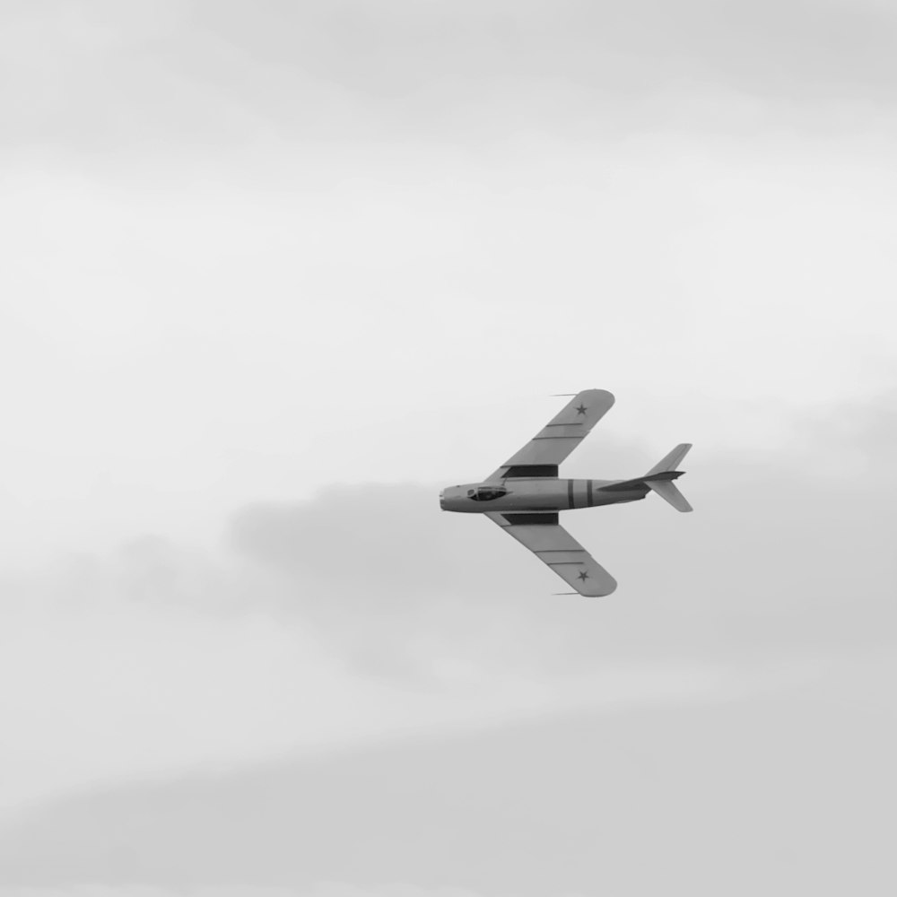 a small airplane flying through a cloudy sky