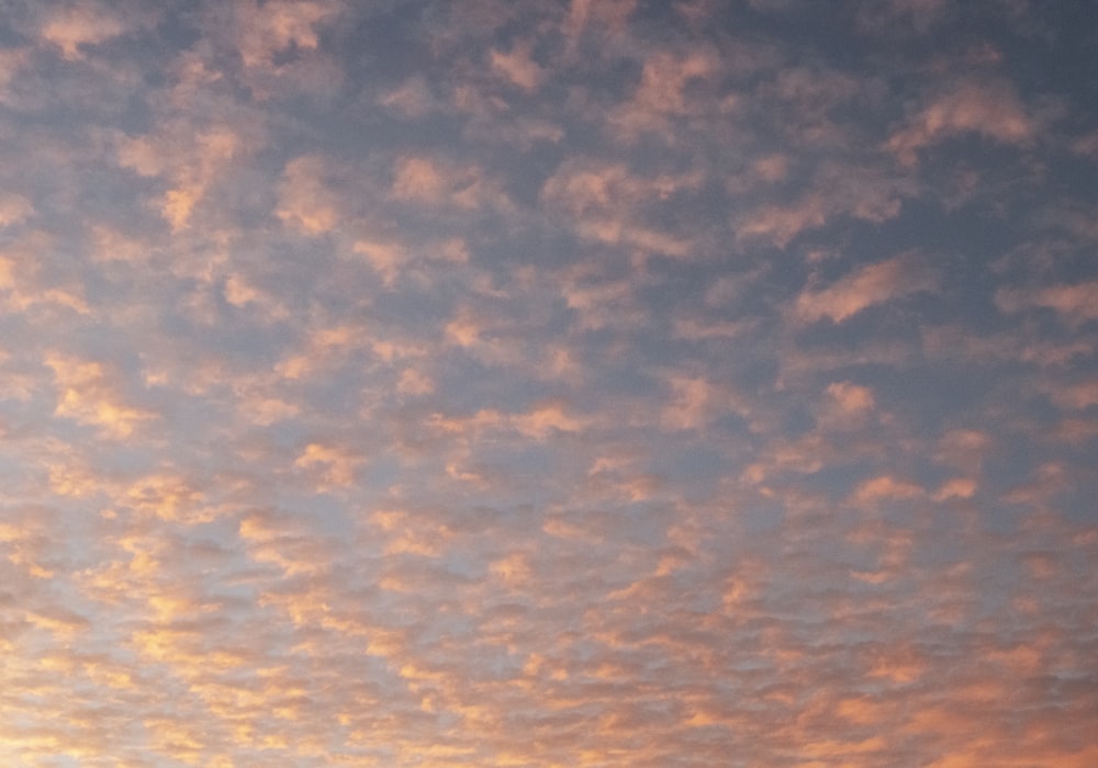 a plane flying in the sky at sunset