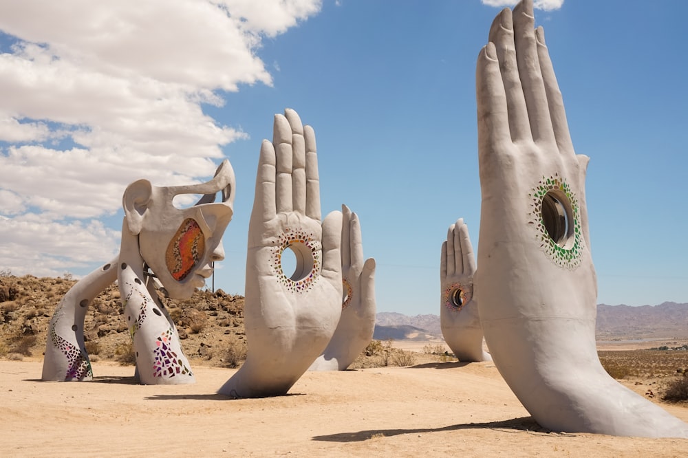 a group of large hand sculptures in the desert