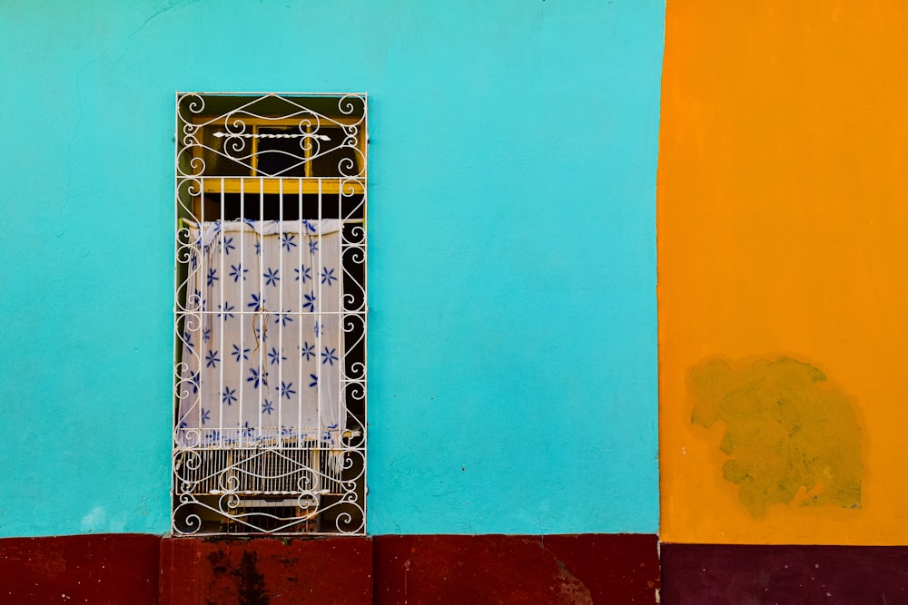a window on a blue and yellow wall