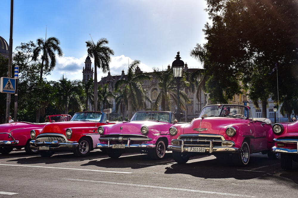 a row of classic cars parked in a parking lot