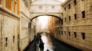 A serene view of Venice’s canals with gondolas gently floating under historic bridges