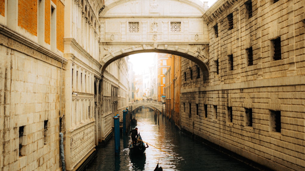 a boat is going down a canal under a bridge