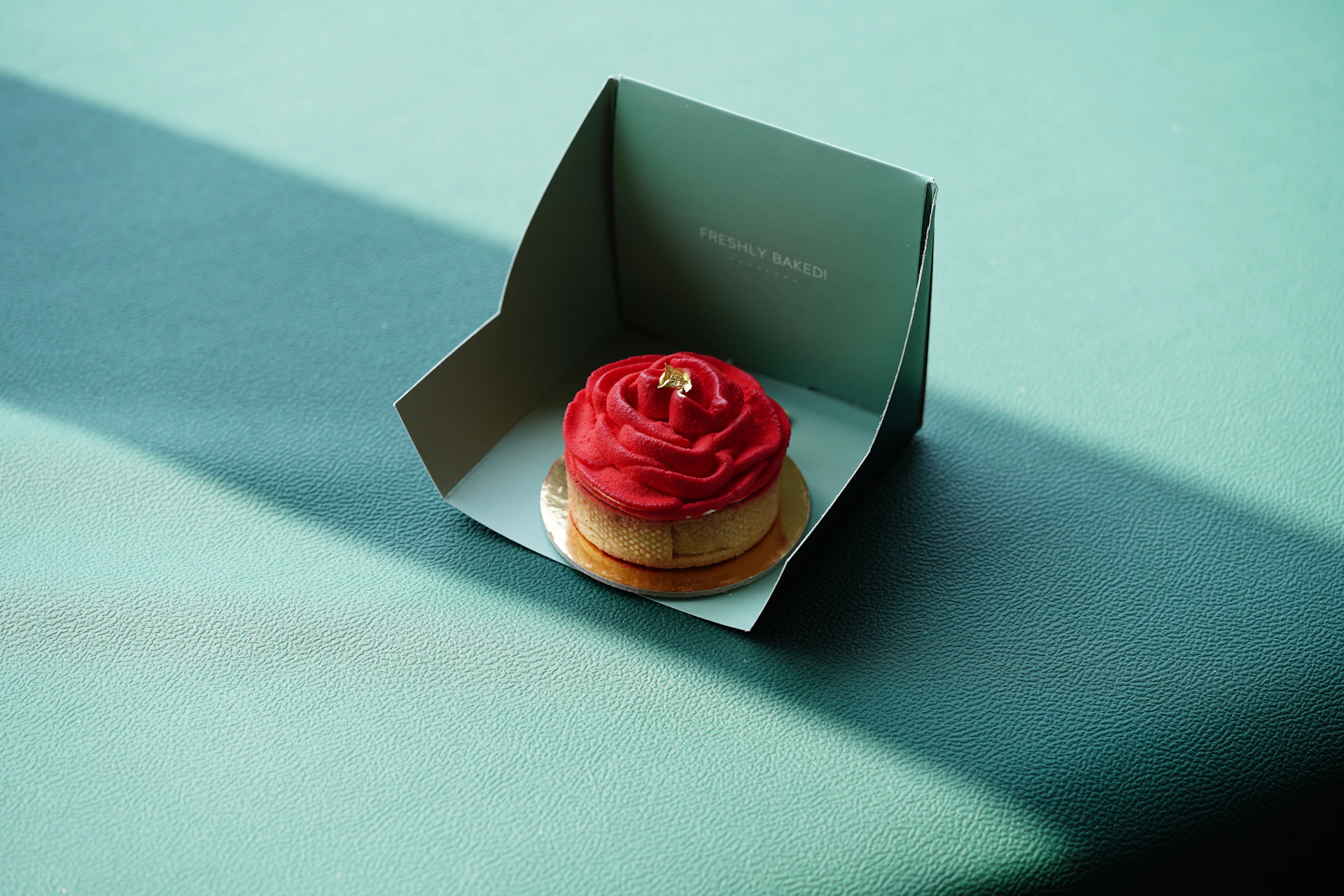 a cupcake with a red frosting sitting in a box