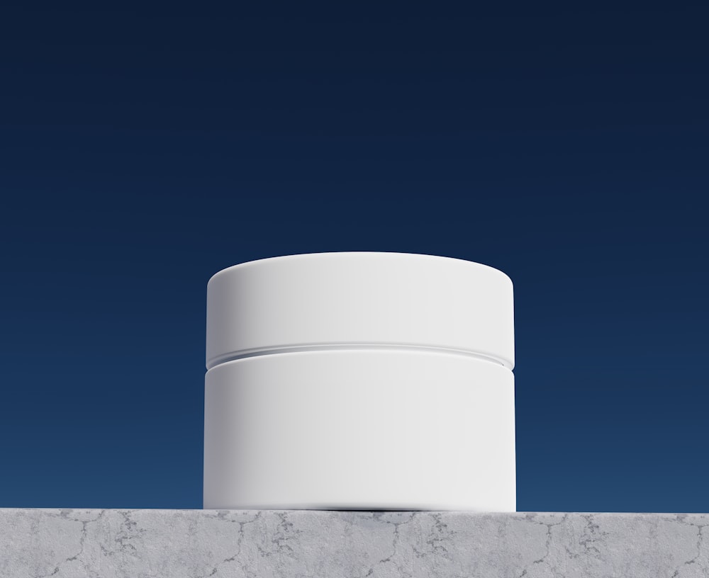 a white cylindrical object sitting on top of a wall