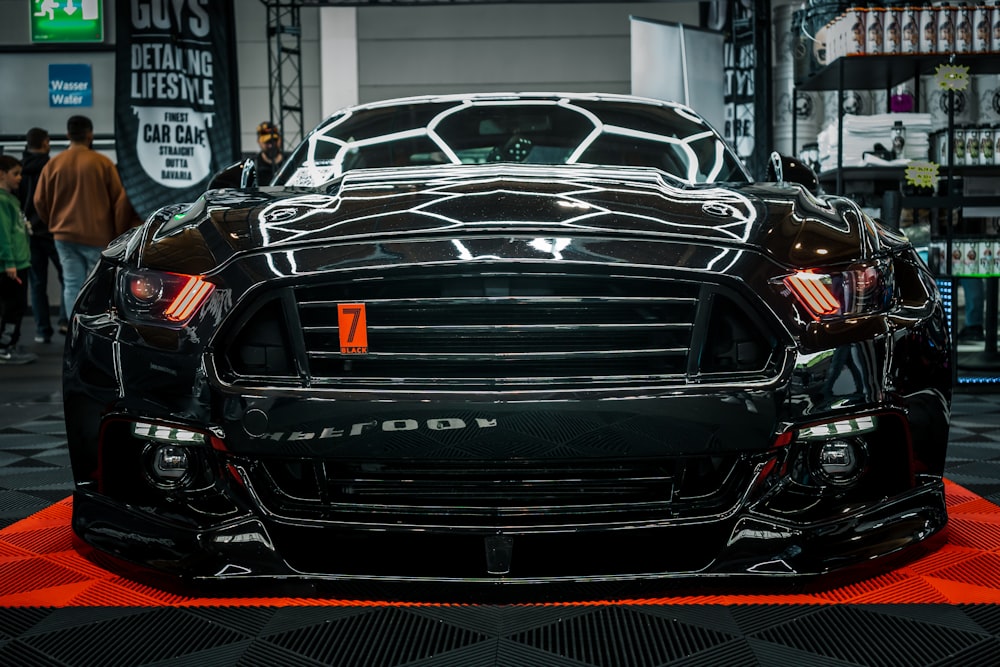 a black sports car is on display at a car show