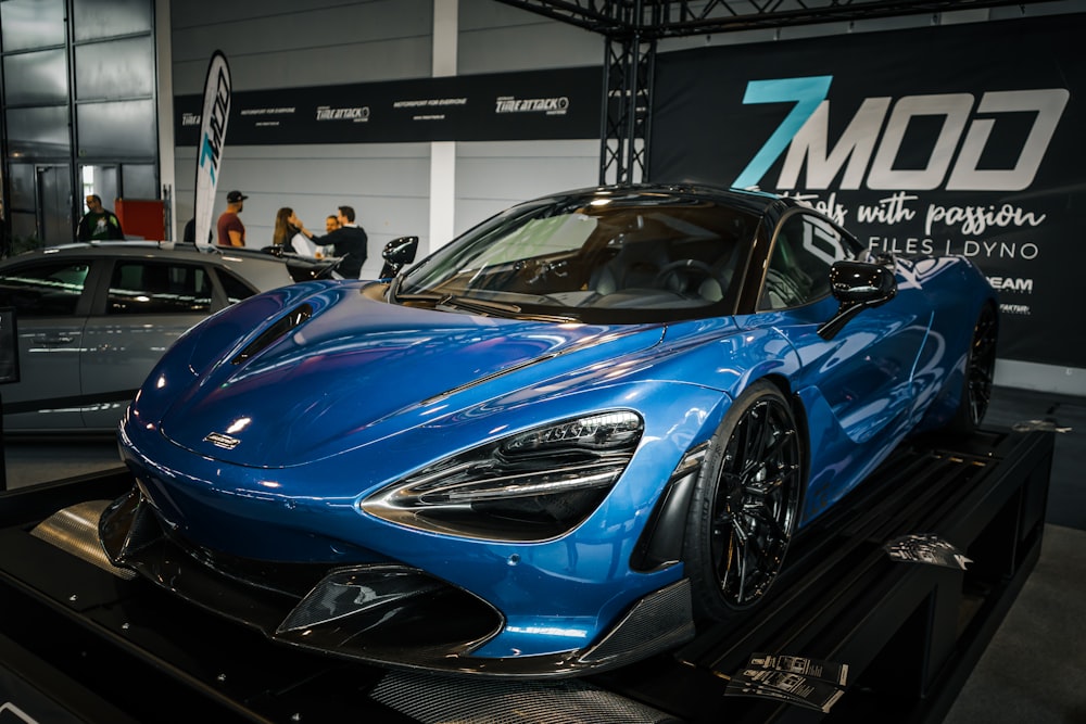 a blue sports car on display at a car show