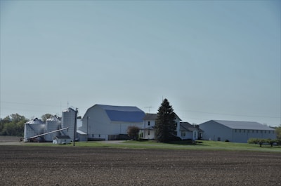 Wide open farmland with a rustic farmhouse in the distance.