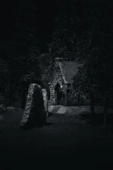 A solemn stone chapel perched on a cliff under a twilight sky.
