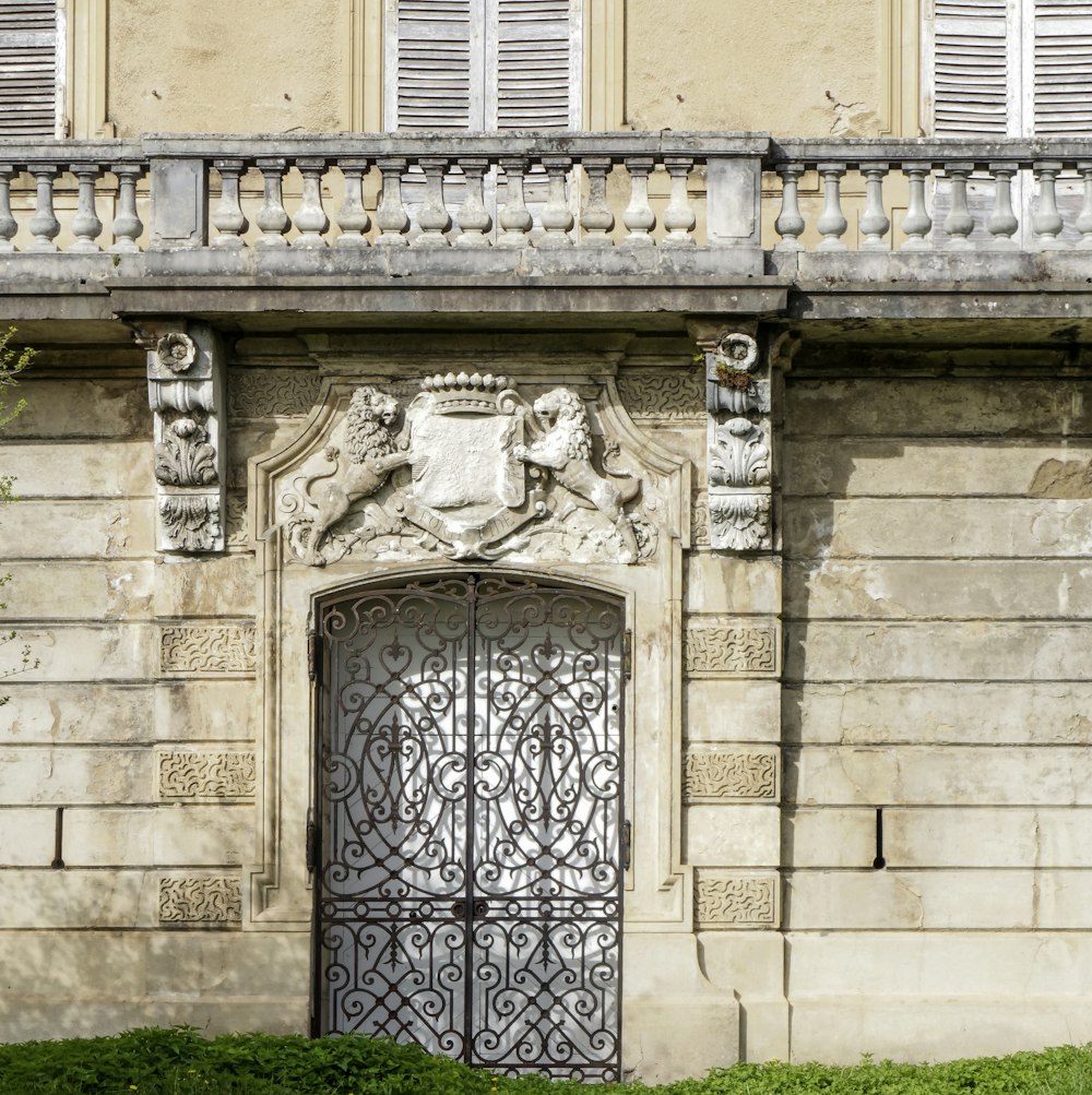 a building with a large iron gate and a green lawn