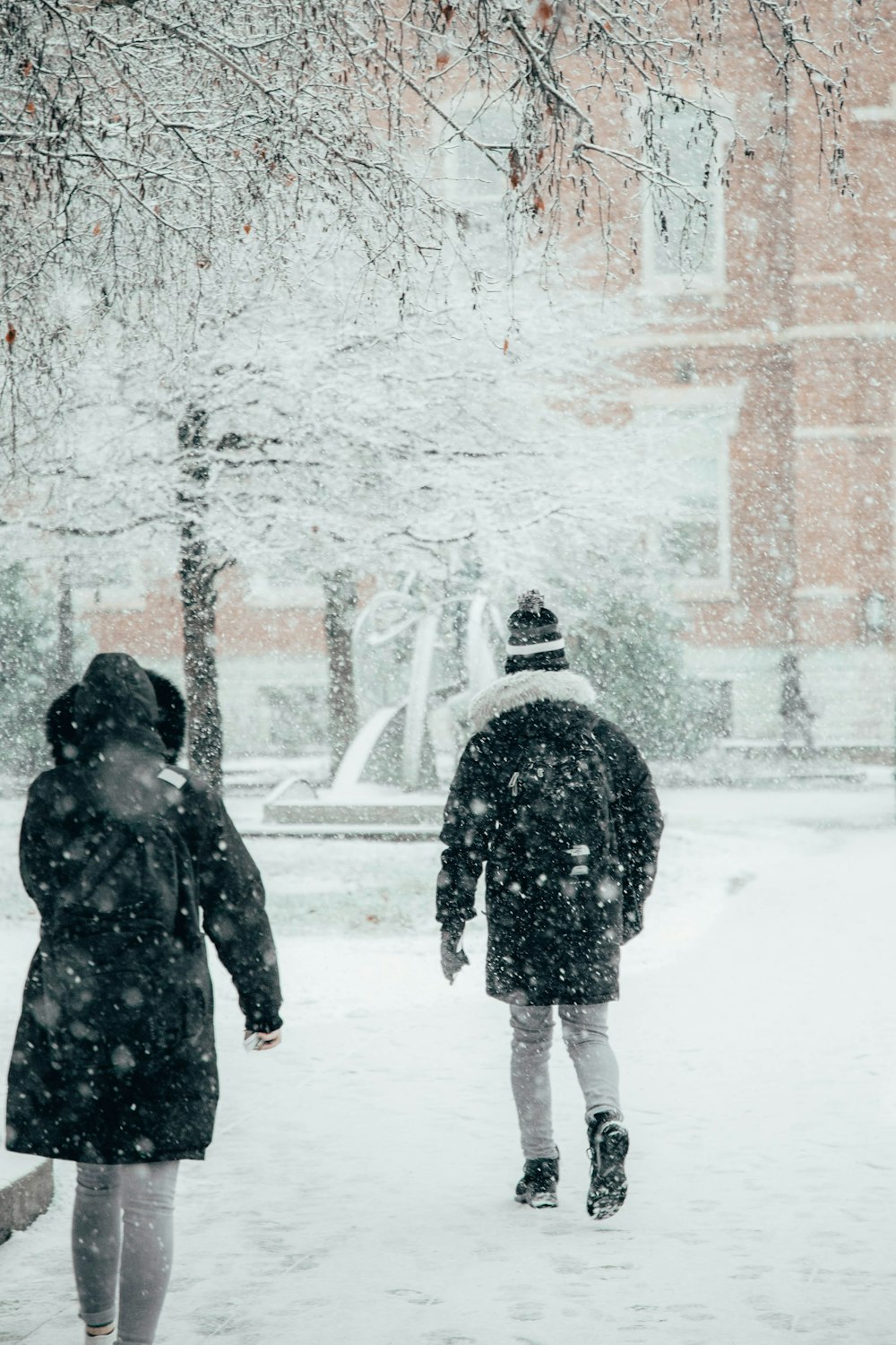 雪の中を歩く男女