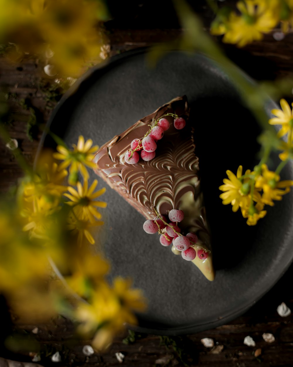 a piece of chocolate cake sitting on top of a black plate