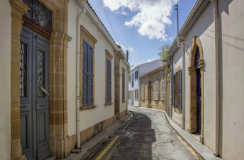 a narrow street lined with old buildings and shutters