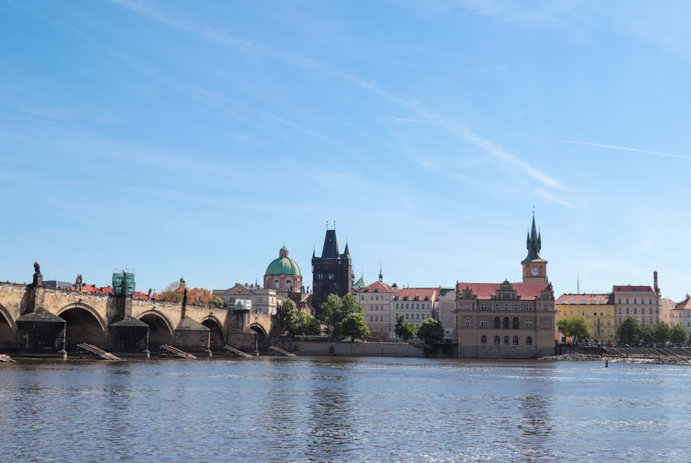 a river with a bridge and buildings in the background