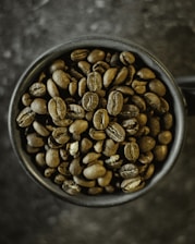 a cup filled with coffee beans on top of a table