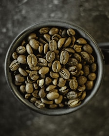 a cup filled with coffee beans on top of a table