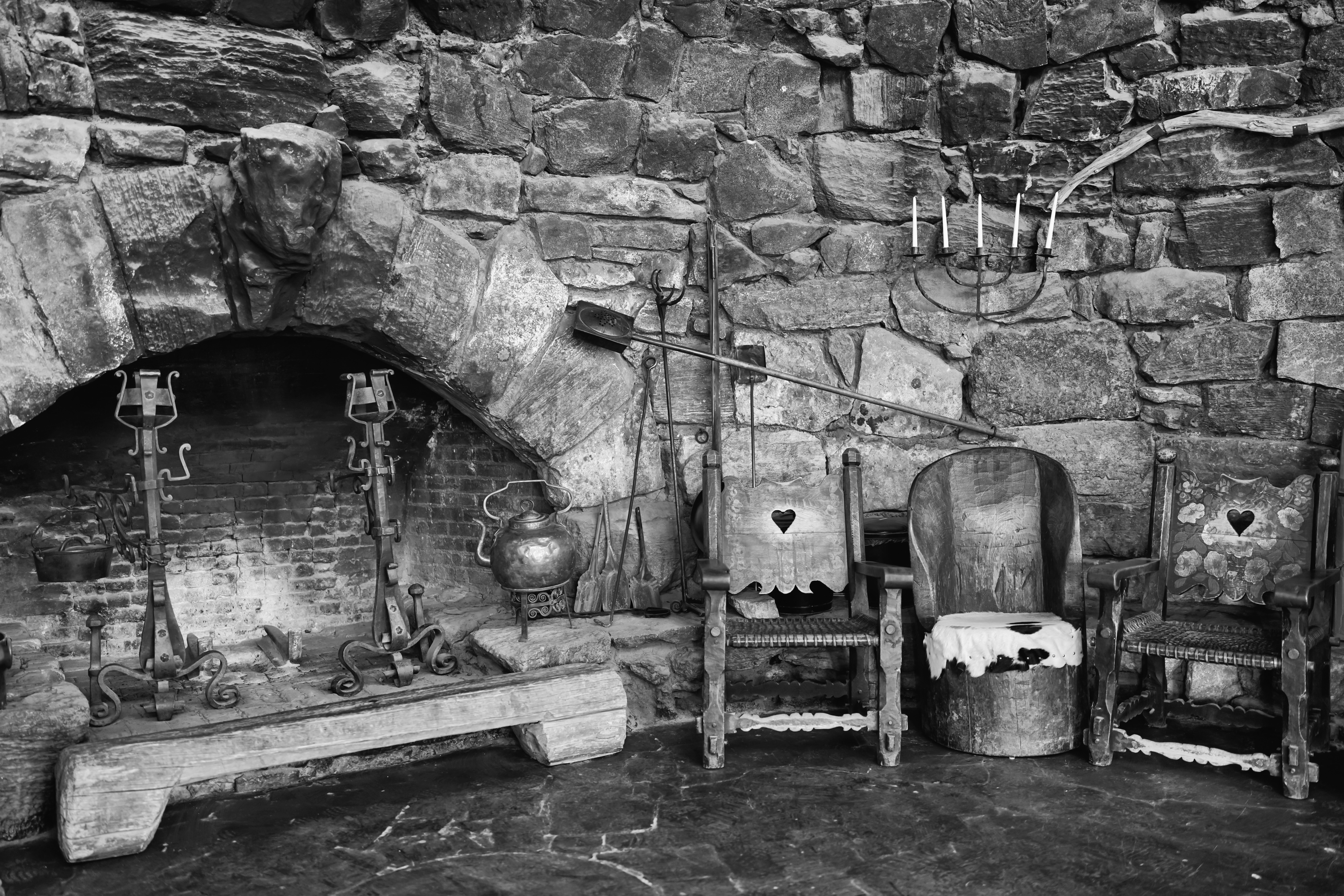 a black and white photo of a stone fireplace