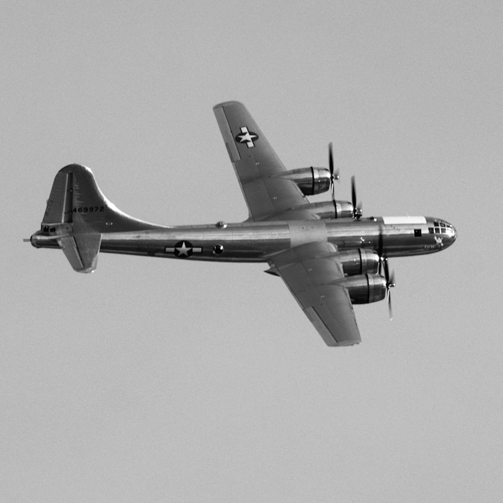 a large propeller plane flying through a gray sky
