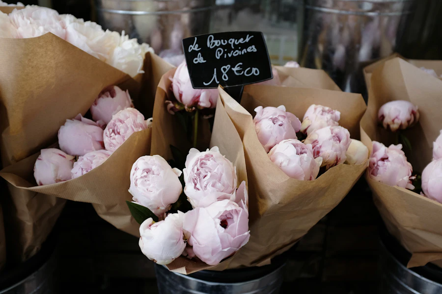 Pivoines en cornets de papier kraft dans des seaux en zinc