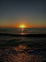 A serene sunset over a calm ocean, reflecting warm hues.