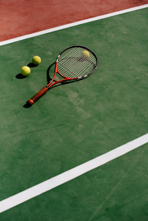 Close-up of tennis balls and racket with training code sheets on the side.