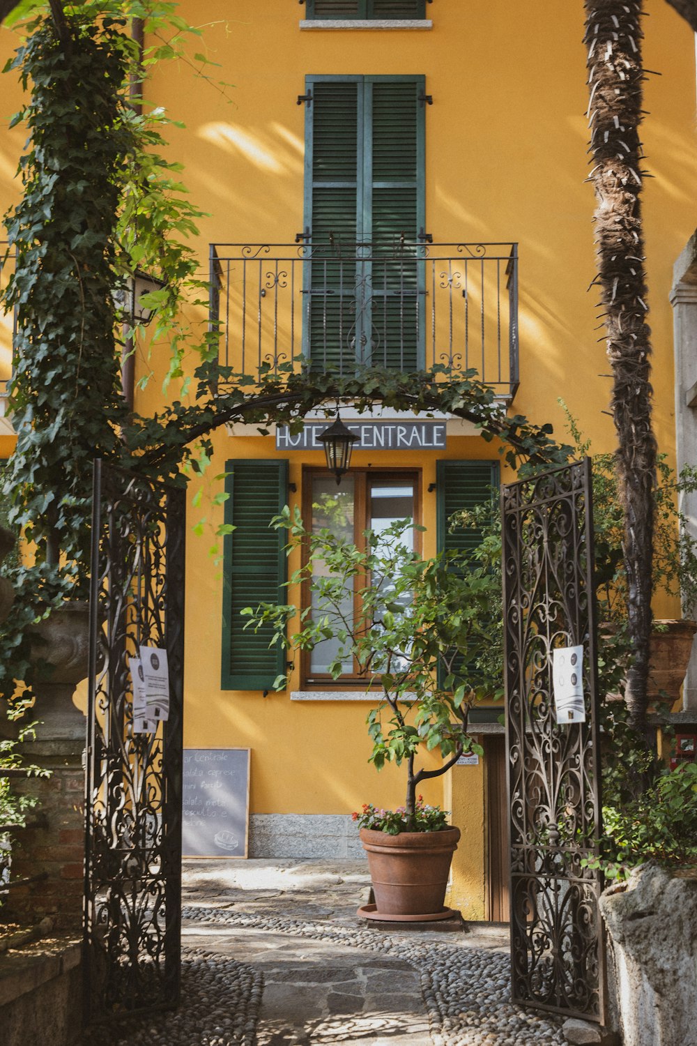 a yellow building with a wrought iron gate