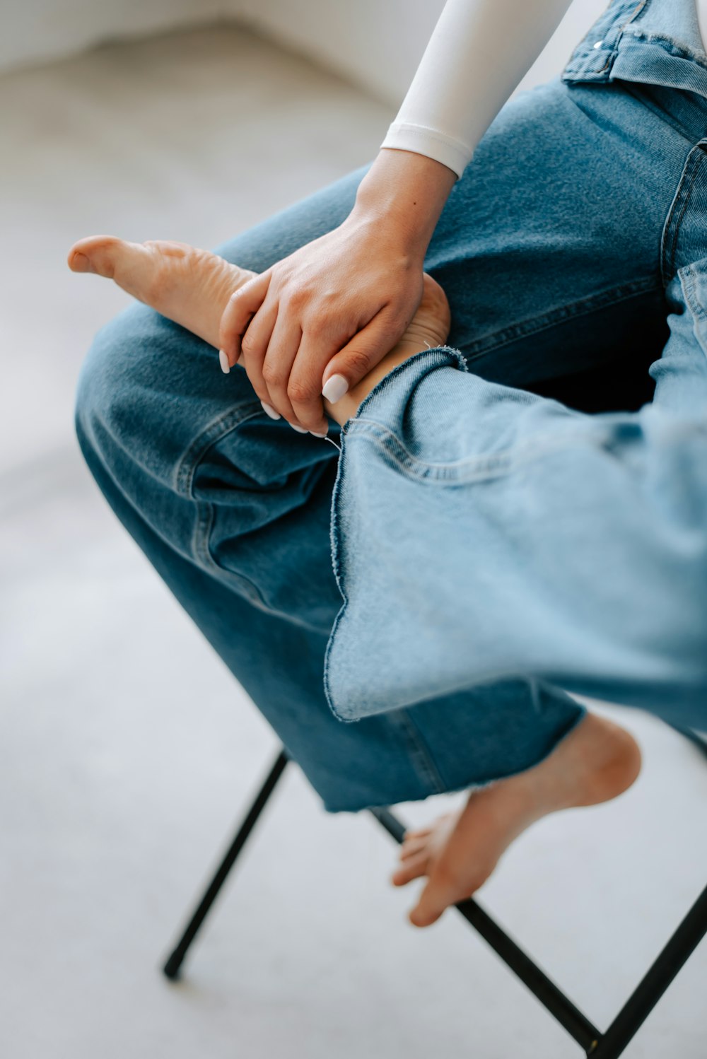 a person sitting on a chair with their hand on the leg of another person