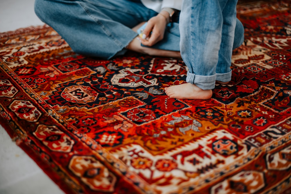 a person sitting on a rug on the floor