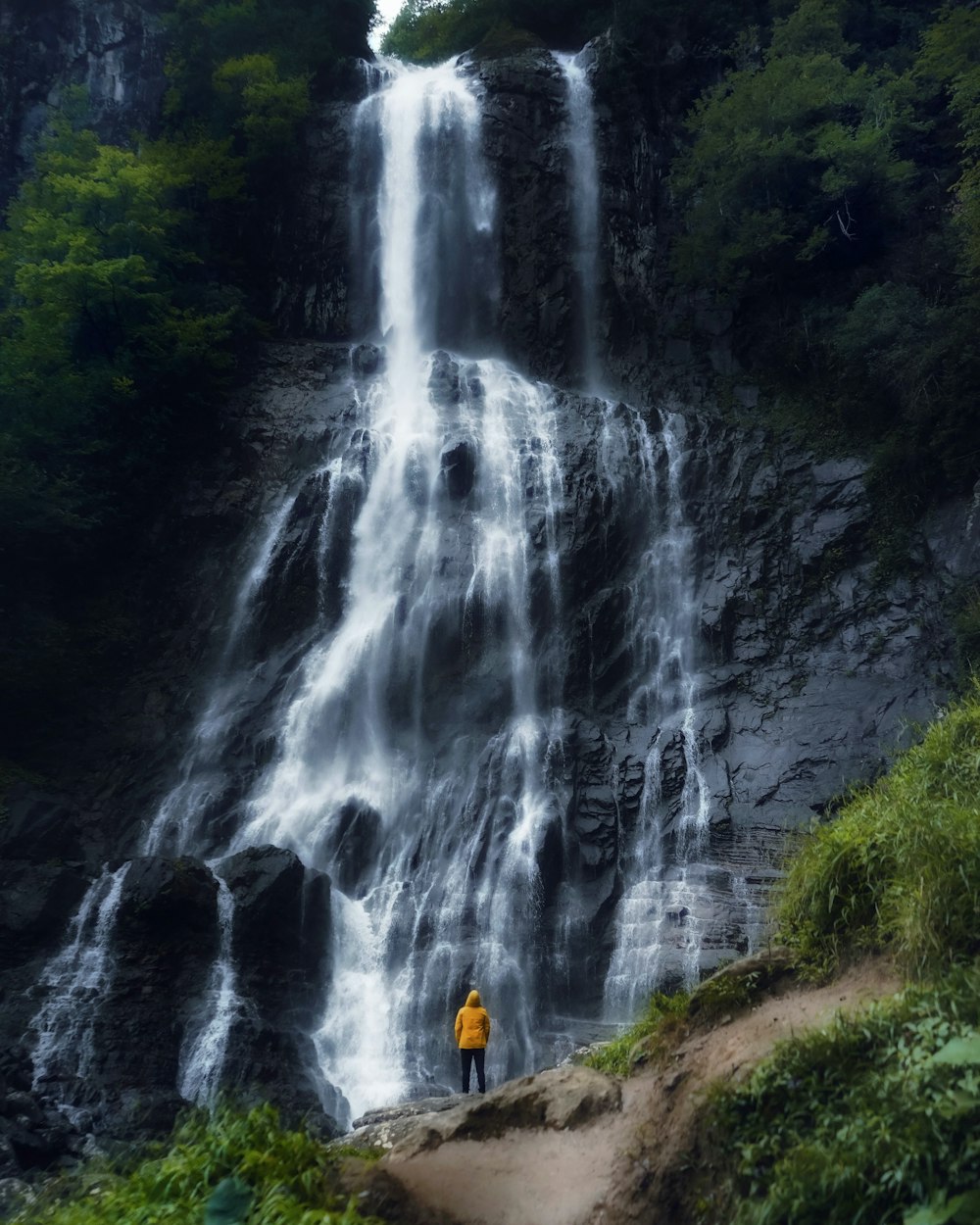 a person standing in front of a waterfall