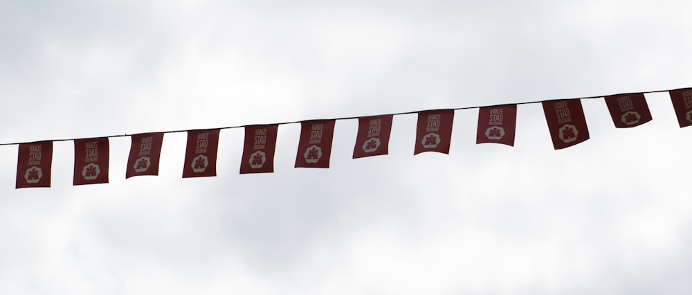 a group of red flags hanging from a line