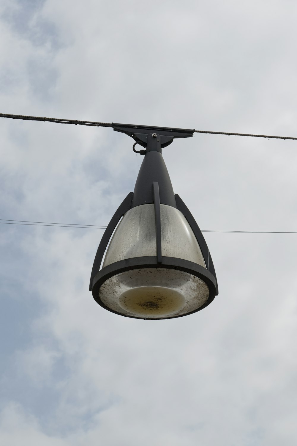 a street light hanging from a wire on a cloudy day