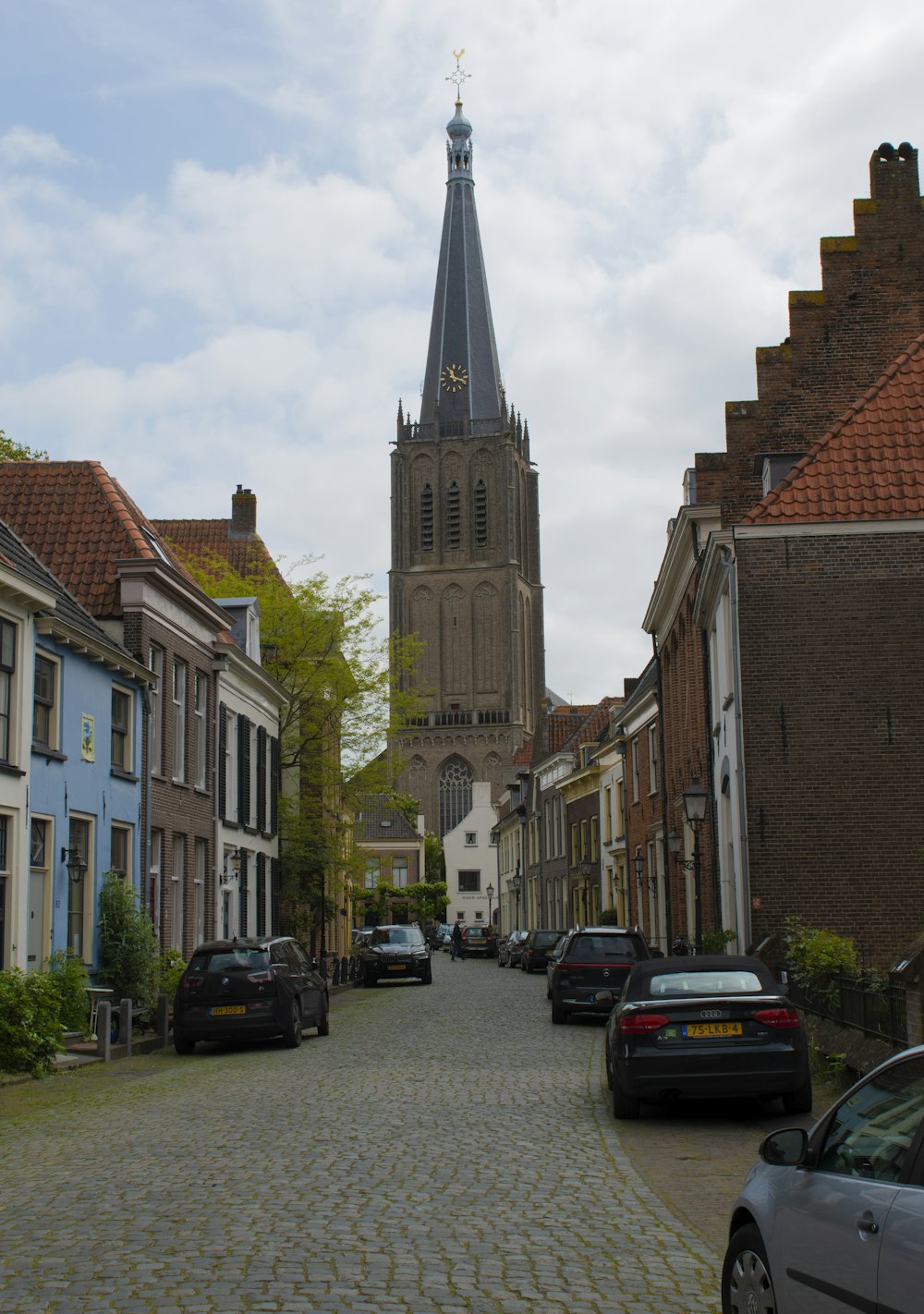 a cobblestone street with a church steeple in the background