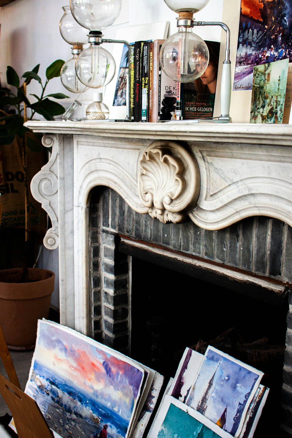 a fire place with paintings on the mantle
