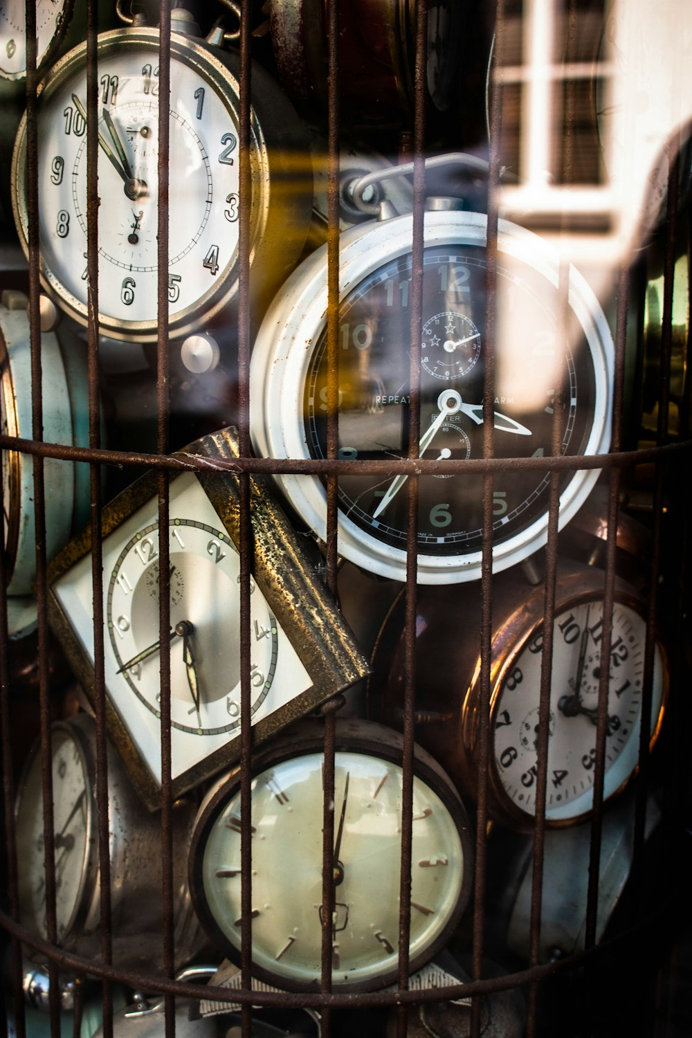 a bunch of clocks that are in a cage
