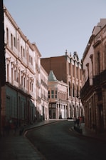 an empty street with a few people walking down it