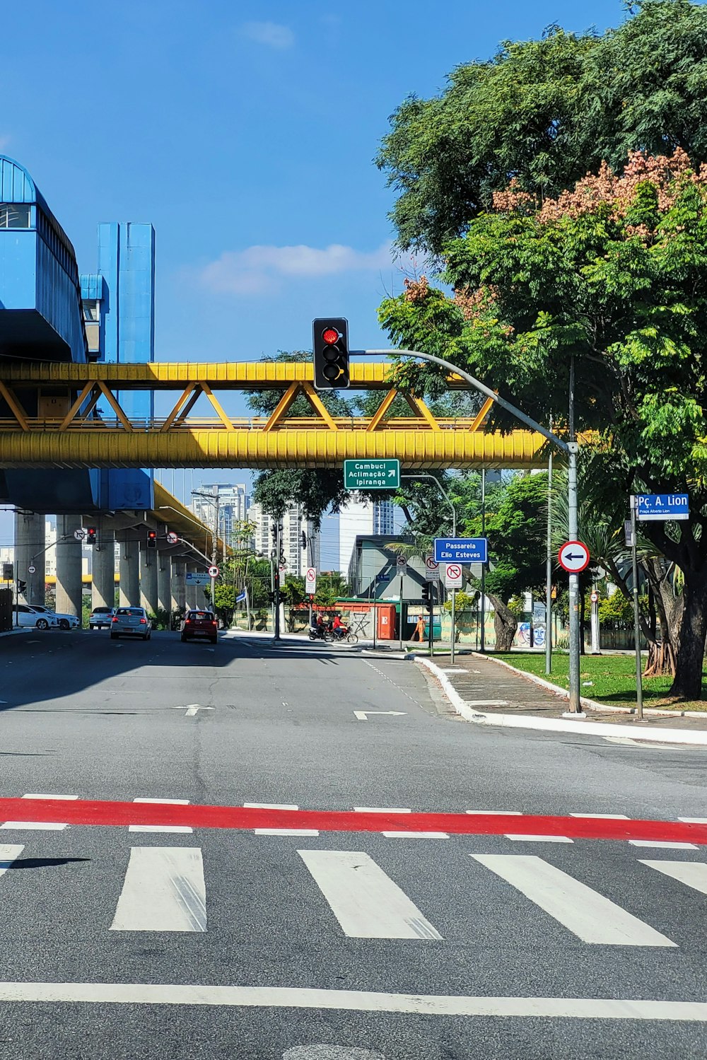 a traffic light on a yellow bridge over a street