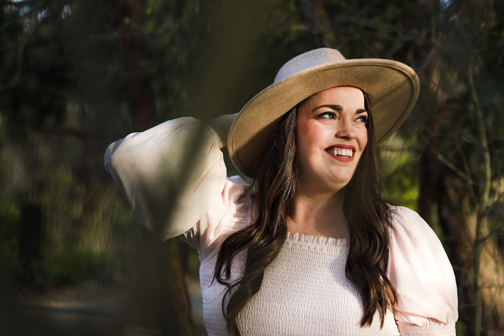 a woman wearing a hat and smiling for the camera