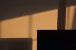 Minimalist sculpture casting soft shadows on a white wall.