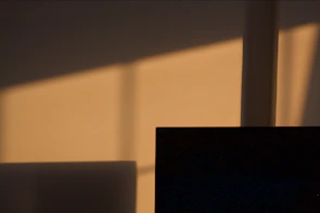 Minimalist sculpture casting soft shadows on a white wall.