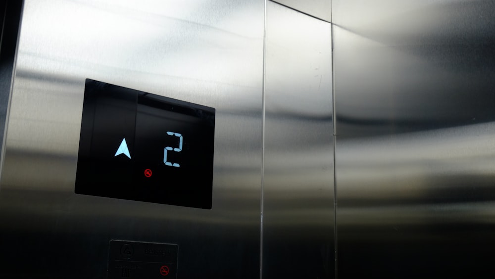 a stainless steel wall with a clock and thermometer