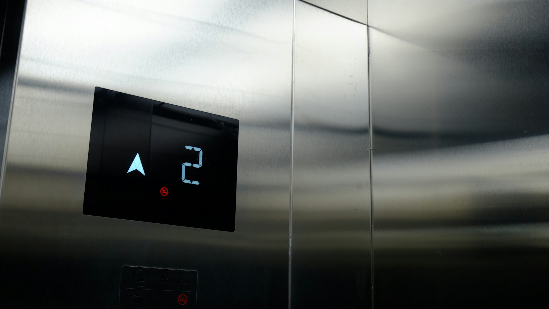 a stainless steel wall with a clock and thermometer