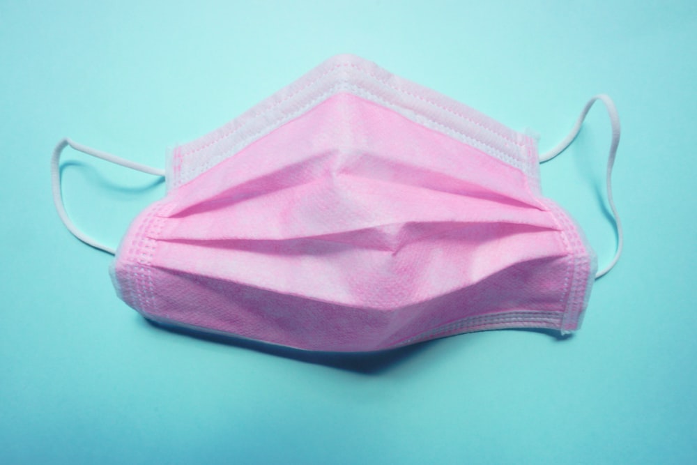 a pink face mask on a blue background