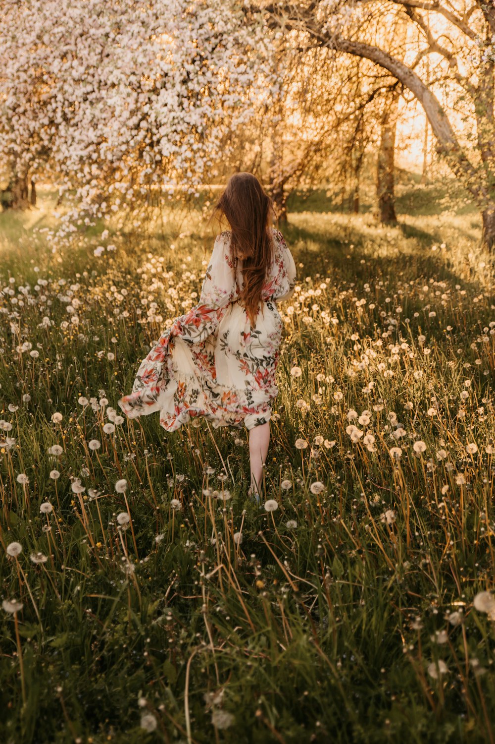 a woman walking through a field of flowers