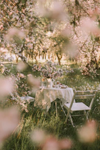 a table and chairs in a field of flowers