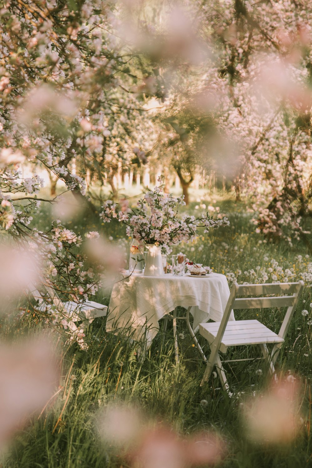 a table and chairs in a field of flowers
