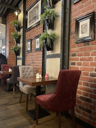 a restaurant with a brick wall and wooden tables