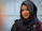 Portrait of a smiling woman wearing a stylish black abaya with delicate embroidery.