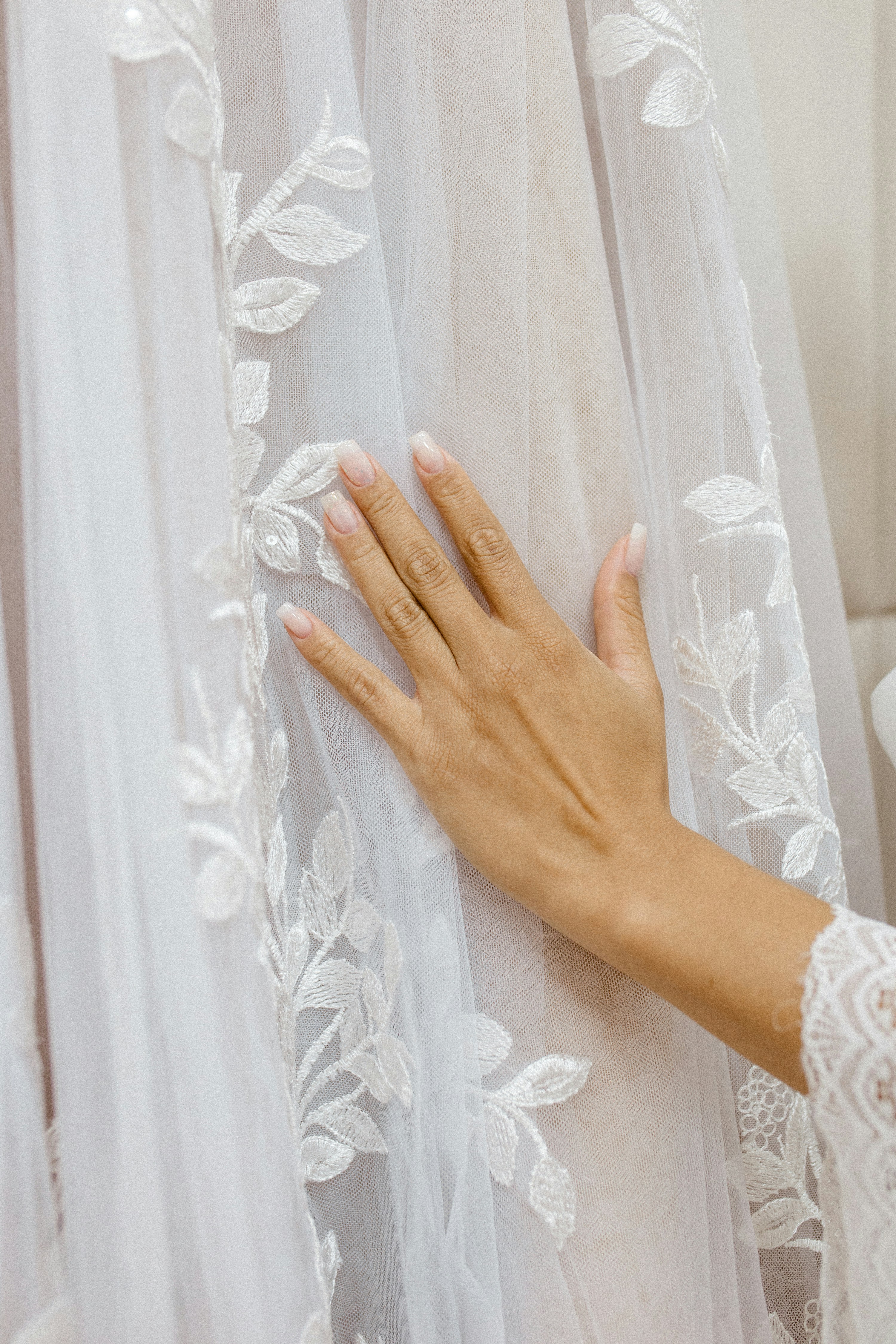 a woman's hand on the back of a wedding dress