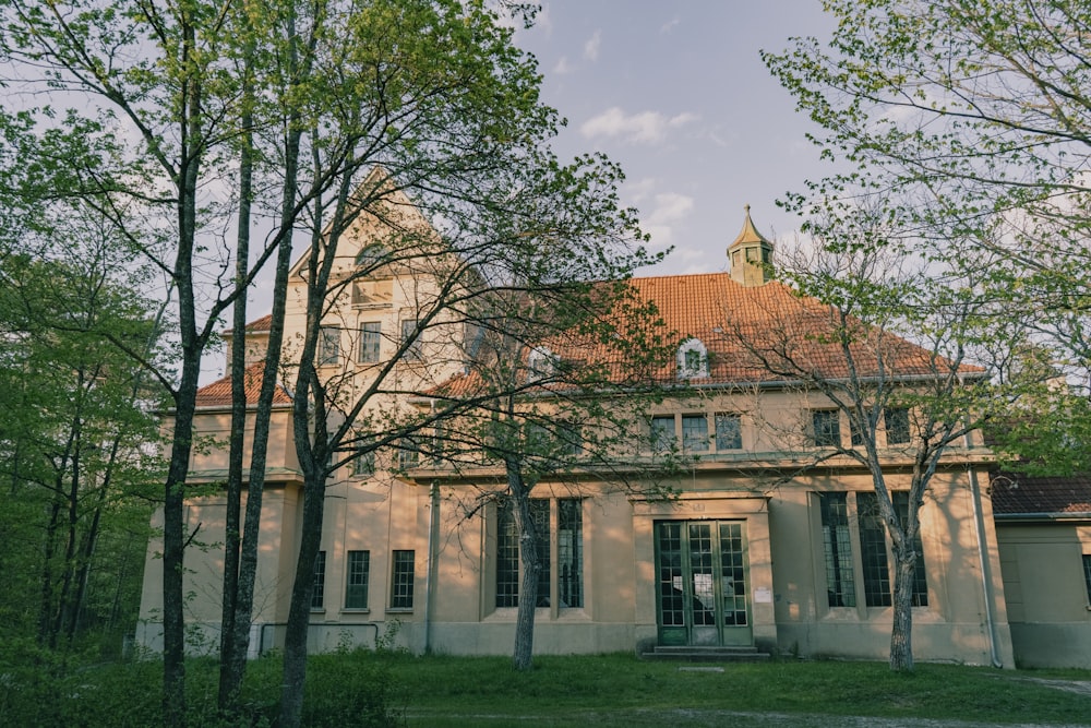 a large building with a red roof surrounded by trees